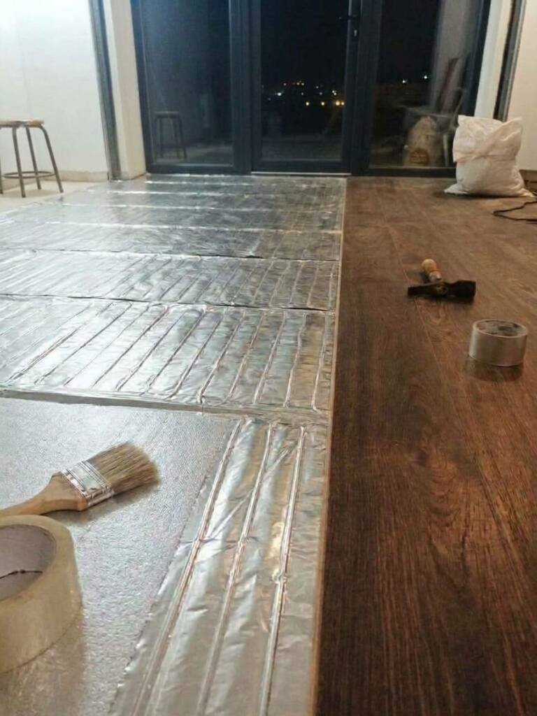 Алюминиевые маты встык на теплоизоляционной подложке, рядом уже уложен ламинат