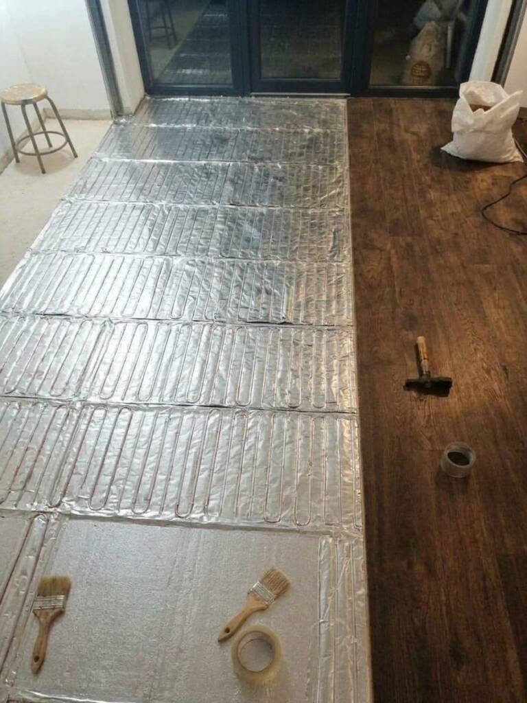 Алюминиевый нагревательный мат под ламинат: полосы мата на подложке перед укладкой ламината